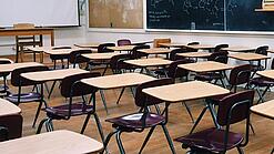 Ein leeres Klassenzimmer mit Stühlen und Pulten.