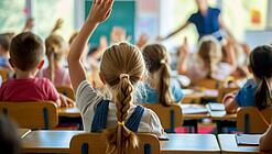 In einer Schulklasse melden sich mehrere Schüler:innen.