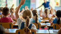 In einer Schulklasse melden sich mehrere Schüler:innen.