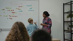 Lehrerin und Schüler an einem Whiteboard.
