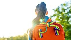 Blick von hinten auf ein Mädchen mit einem Rucksack.