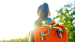 Blick von hinten auf ein Mädchen mit einem Rucksack.
