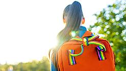 Blick von hinten auf ein Mädchen mit einem Rucksack.