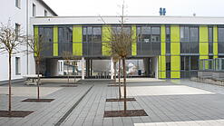 Ein modernes Schulgebäude und der Schulhof.