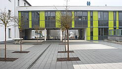 Ein modernes Schulgebäude und der Schulhof.