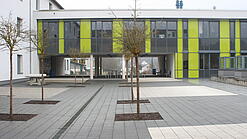 Ein modernes Schulgebäude und der Schulhof.