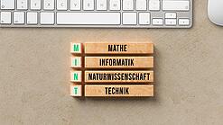 Schild, das den Begriff MINT erklärt: Mathe, Inforamtik, Naturwissenschaft, Technik.
