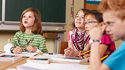 Grundschulkinder sitzen in einem Klassenraum.