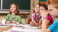 Grundschulkinder sitzen in einem Klassenraum.