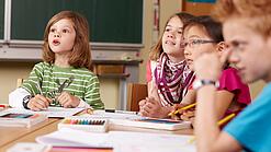 Grundschulkinder sitzen in einem Klassenraum.