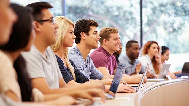 Verschiedene Studierende sitzen in einem Seminarsaal.