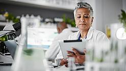 Frau in einem Labor mit einem Tablet in der Hand.