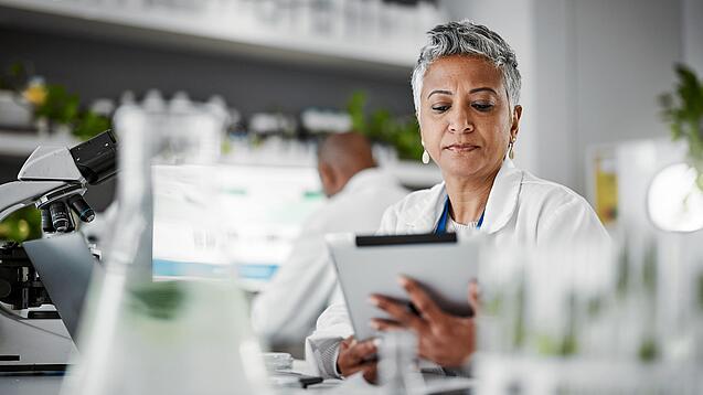 Frau in einem Labor mit einem Tablet in der Hand.