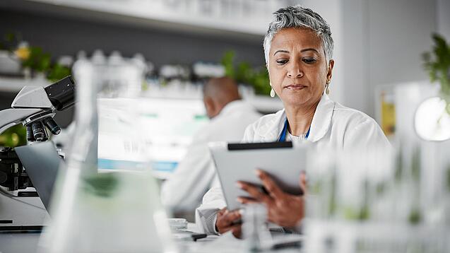 Frau in einem Labor mit einem Tablet in der Hand.