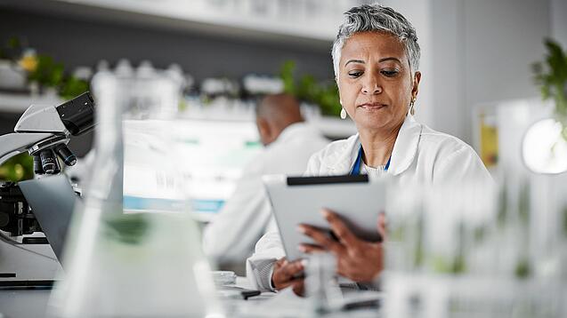 Frau in einem Labor mit einem Tablet in der Hand.