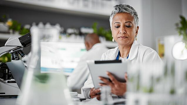Frau in einem Labor mit einem Tablet in der Hand.