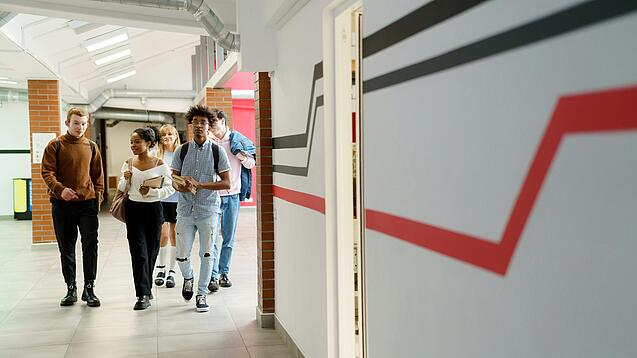 Studierende laufen einen Gang entlang.