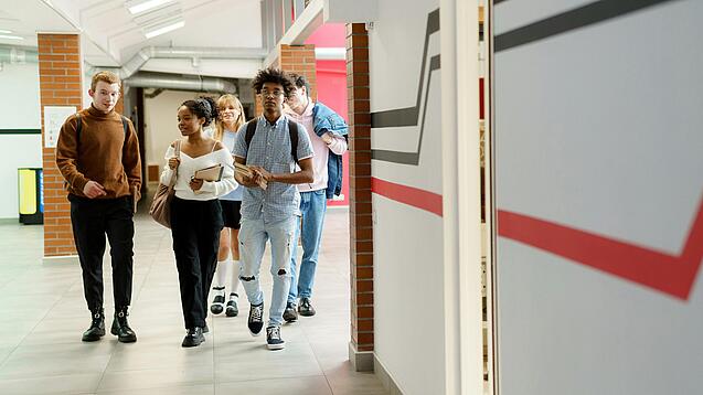 Studierende laufen einen Gang entlang.