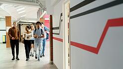 Studierende laufen einen Gang entlang.