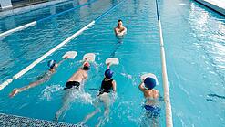 Kleine Gruppe von Kindern beim Schwimmunterricht.