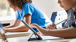 Schulkinder arbeiten mit einem Tablet.
