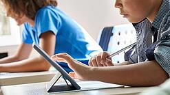 Schulkinder arbeiten mit einem Tablet.