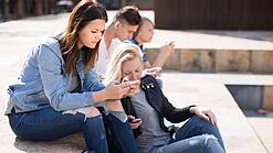 Gruppe Jugendlicher am Handy auf dem Schulhof