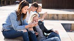 Gruppe Jugendlicher am Handy auf dem Schulhof
