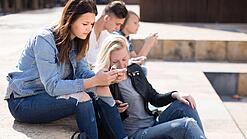 Gruppe Jugendlicher am Handy auf dem Schulhof