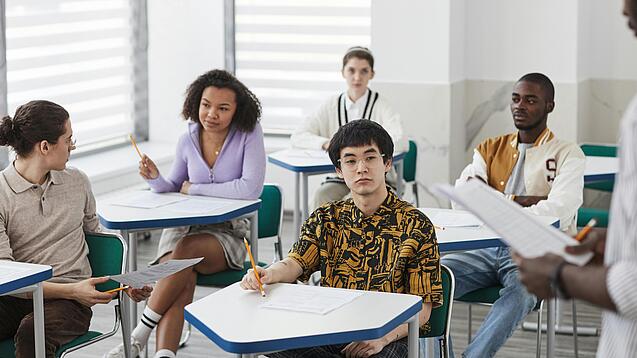 Schüler:innen einer weiterführenden Schule sitzen im Unterricht.