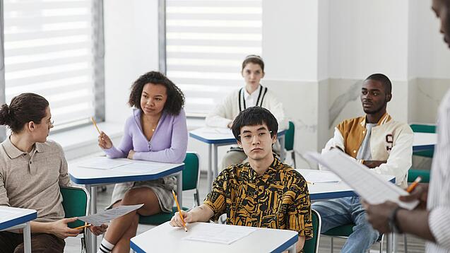 Schüler:innen einer weiterführenden Schule sitzen im Unterricht.
