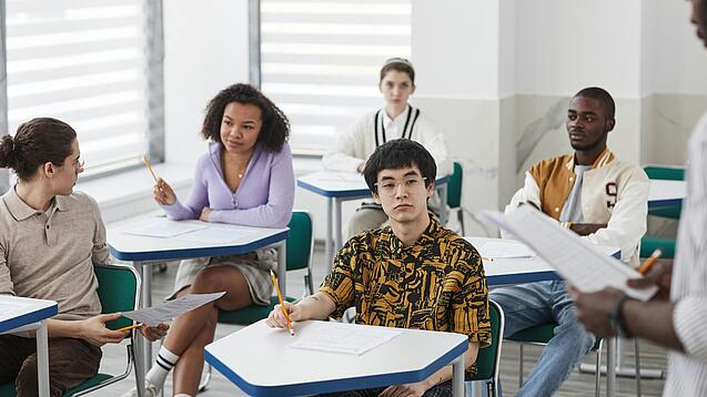 Schüler:innen einer weiterführenden Schule sitzen im Unterricht.