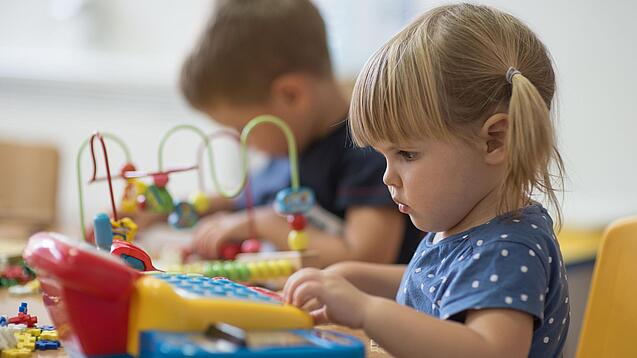 Zwei Kleinkinder spielen mit Spielsachen.