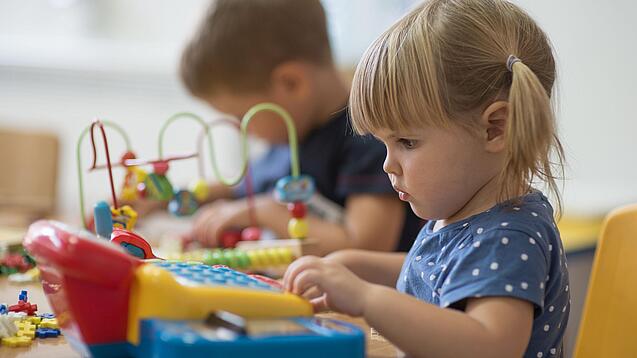 Zwei Kleinkinder spielen mit Spielsachen.