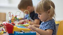 Zwei Kleinkinder spielen mit Spielsachen.