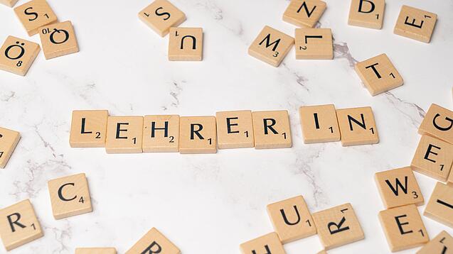 Buchstabenplättchen ergeben das Wort Lehrer:in.