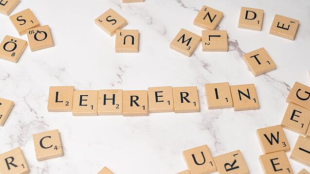 Buchstabenplättchen ergeben das Wort Lehrer:in.