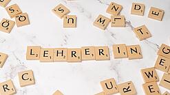 Buchstabenplättchen ergeben das Wort Lehrer:in.