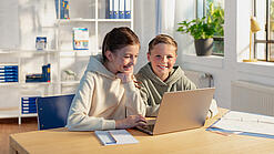 Zwei Kinder vor einem Laptop