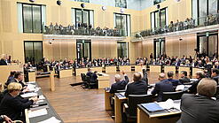 Viele Menschen sitzen an Tischen im Bundesrat.