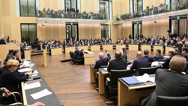 Viele Menschen sitzen an Tischen im Bundesrat.