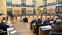 Viele Menschen sitzen an Tischen im Bundesrat.