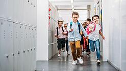 Kinder laufen in einem Schulflur.