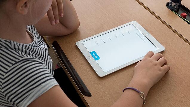 Eine Schülerin schaut auf ein Tablet.