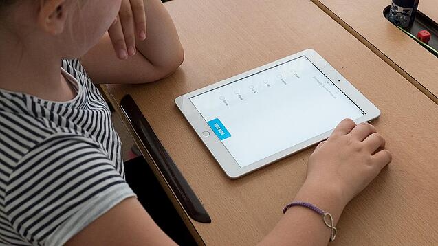 Eine Schülerin schaut auf ein Tablet.