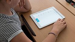 Eine Schülerin schaut auf ein Tablet.