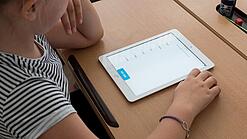 Eine Schülerin schaut auf ein Tablet.