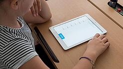 Eine Schülerin schaut auf ein Tablet.