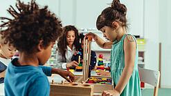 Kinder spielen in einer Kita mit Bauklötzen.