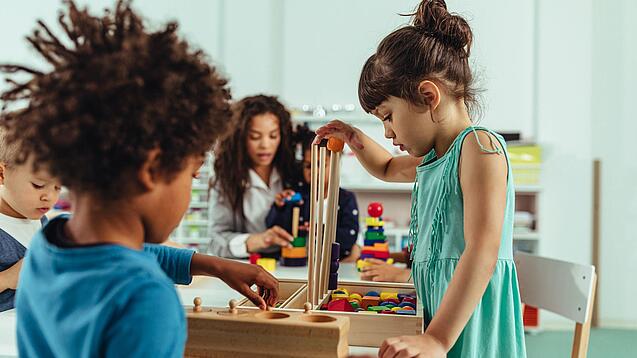 Kinder spielen in einer Kita mit Bauklötzen.